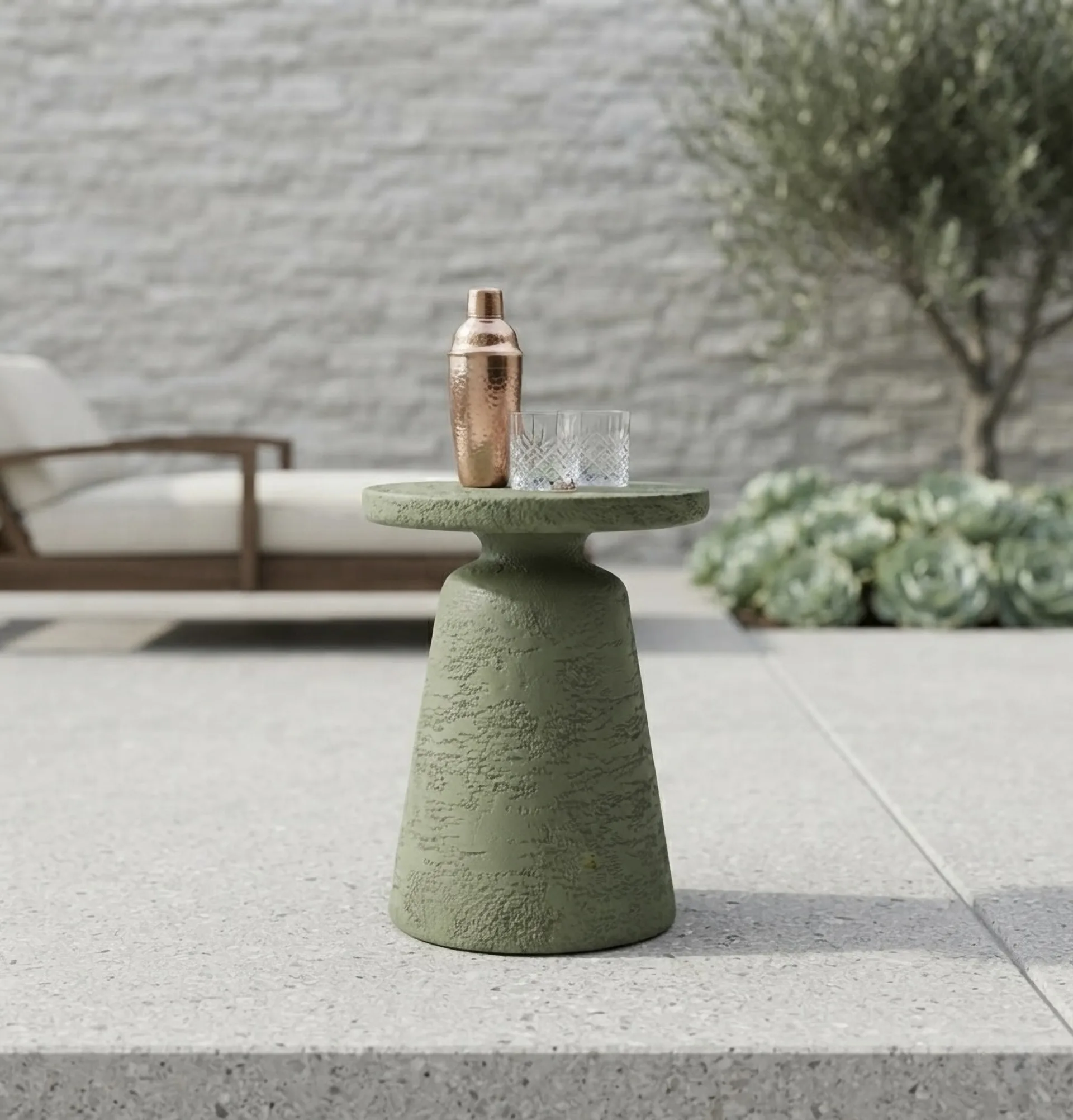 Olea on a pale terrace against a white brick wall, holding a shaker and a glass